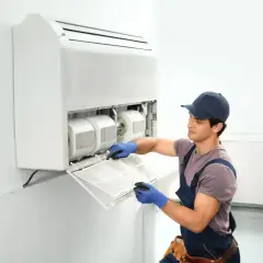 Técnico limpiando el filtro de un aire acondicionado sin unidad exterior.