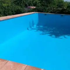 Piscina vacía con paredes pintadas de azul brillante, mostrando que se puede pintar una piscina encima del gresite.
