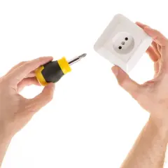 Manos sujetan destornillador y enchufe, listos para aprender como poner un enchufe en un cable.