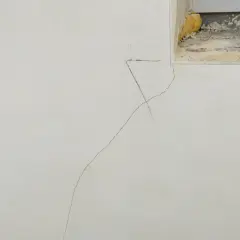 Grieta fina en pared de yeso, indicando la necesidad de reparar grietas por asentamiento. Se observa una marca de lápiz cerca de la grieta.