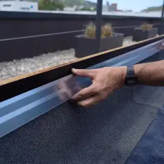 Instalando perfil metálico en borde de tejado, parte del proceso de como poner tela asfaltica.