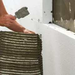 Aplicando mortero para fachadas exteriores sobre poliestireno expandido. El mejor mortero para fachadas exteriores se aplica con llana.