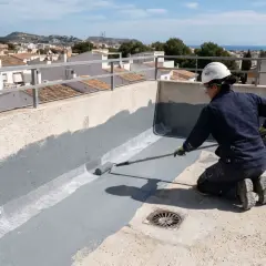 Persona impermeabiliza terraza con rodillo, aplicando pintura gris sobre malla de refuerzo.