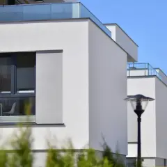Edificios modernos con fachadas blancas y balcones de cristal, cumpliendo la normativa sobre estética fachadas de edificios.