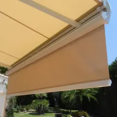 Toldo desplegado, listo para cambiar tela. Sombra agradable en el jardín con palmeras.