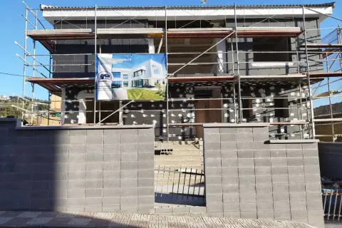 Edificio en construcción con andamios. Un cartel muestra un diseño moderno, quizás para una **ley propiedad horizontal sate**.