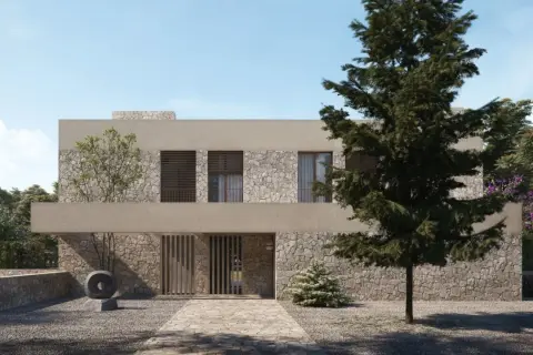 Una casa moderna con fachada de piedra y estuco, ideal para renovar fachada casa. El camino de entrada conduce a una puerta de madera.