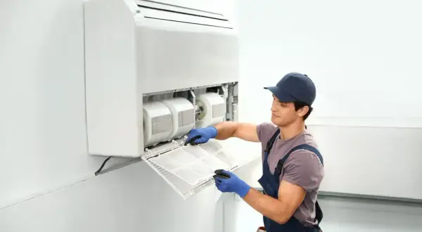 Técnico limpiando el filtro de un aire acondicionado sin unidad exterior.