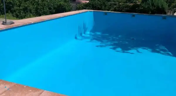 Piscina vacía con paredes pintadas de azul brillante, mostrando que se puede pintar una piscina encima del gresite.