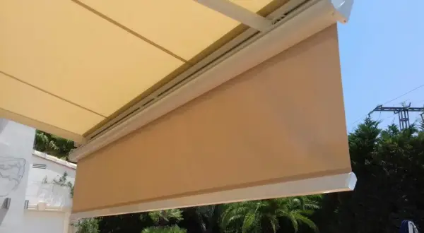 Toldo desplegado, listo para cambiar tela. Sombra agradable en el jardín con palmeras.