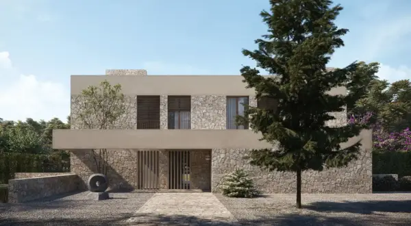 Una casa moderna con fachada de piedra y estuco, ideal para renovar fachada casa. El camino de entrada conduce a una puerta de madera.