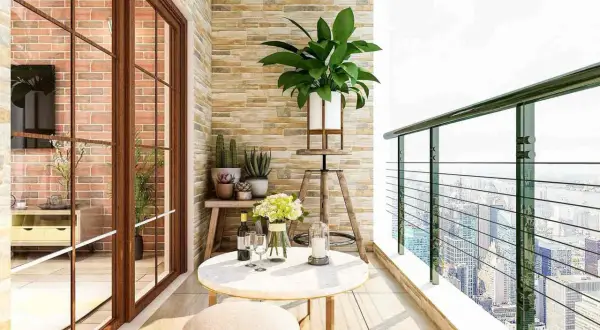 Ideas para decorar un balcón pequeño: mesa redonda, taburete, plantas y vistas urbanas.
