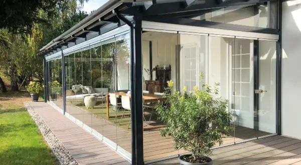 Porche acristalado con muebles de interior. Una idea para como cerrar un porche de forma económica y disfrutarlo todo el año.