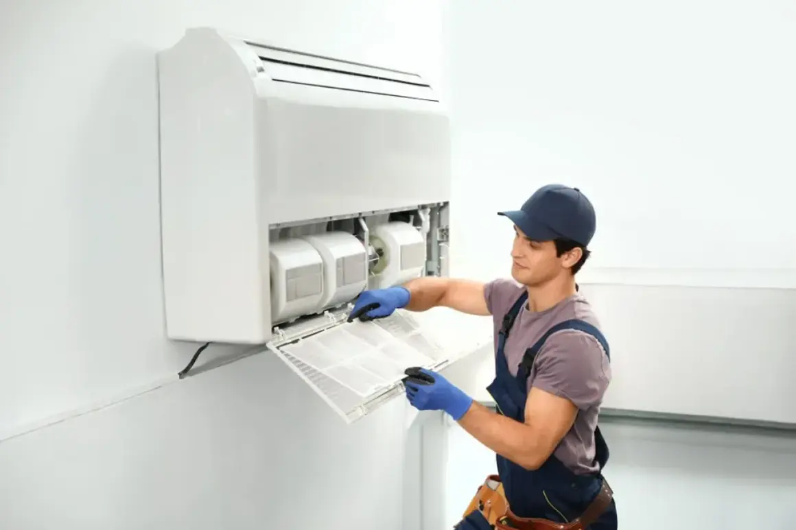 Técnico limpiando el filtro de un aire acondicionado sin unidad exterior.