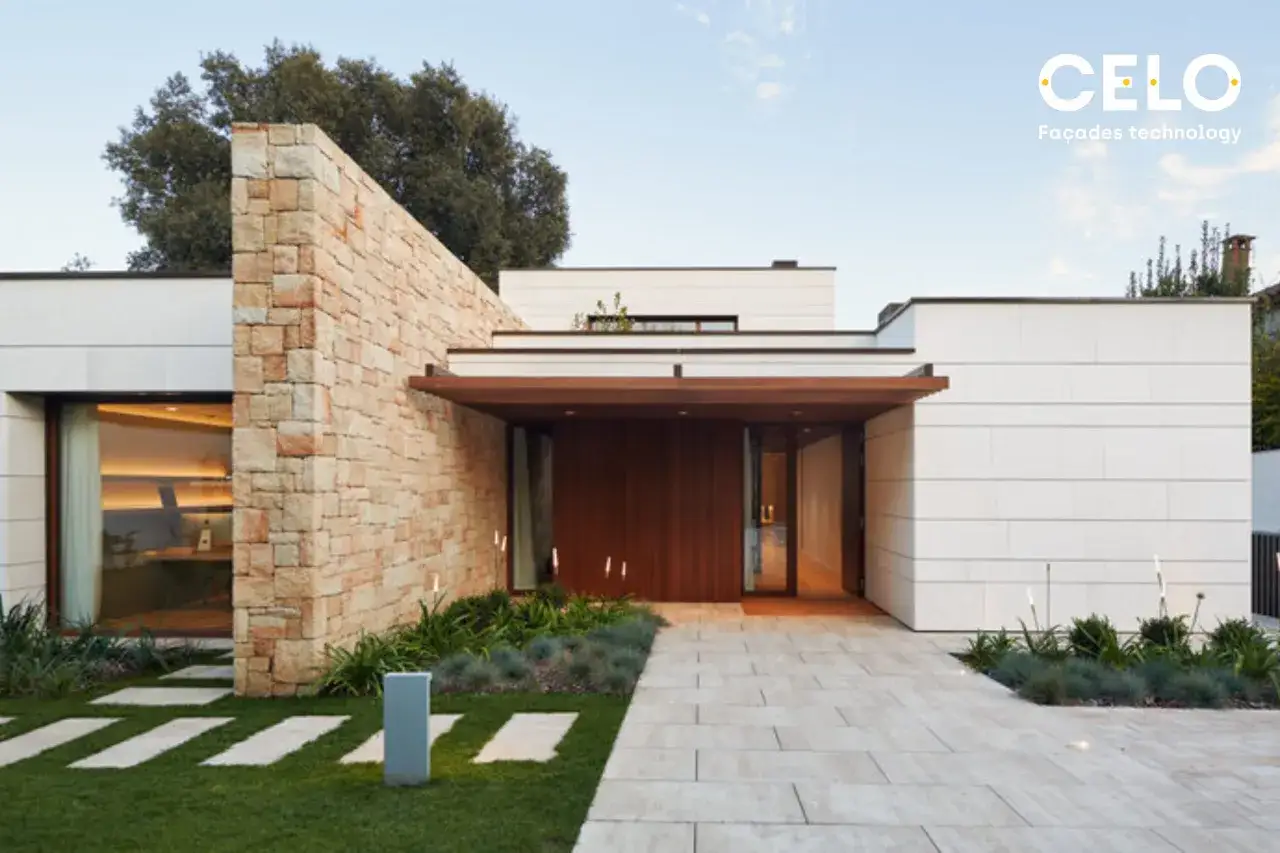 Una casa moderna con fachada de piedra y madera, un camino de baldosas y césped. Inspiración para casas con diseño contemporáneo.