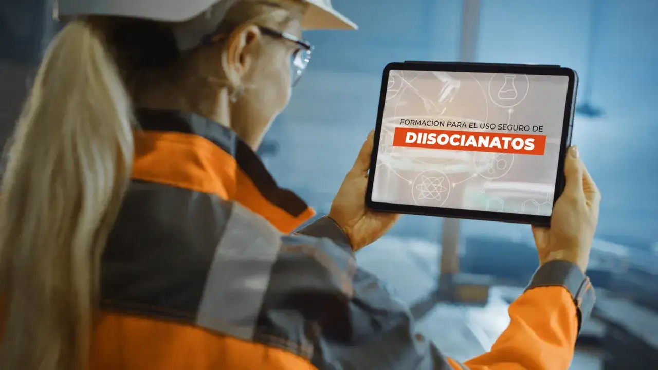Profesional con casco y chaleco naranja revisa en tablet 