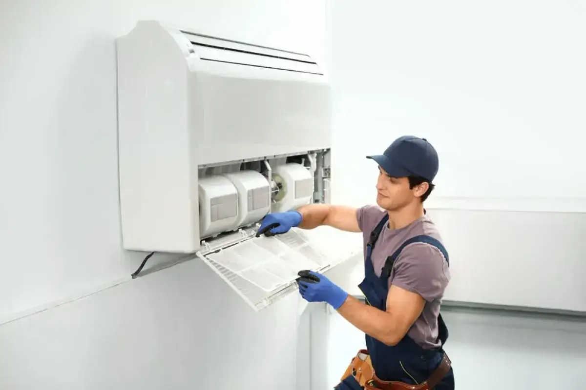 Técnico limpiando el filtro de un aire acondicionado sin unidad exterior.
