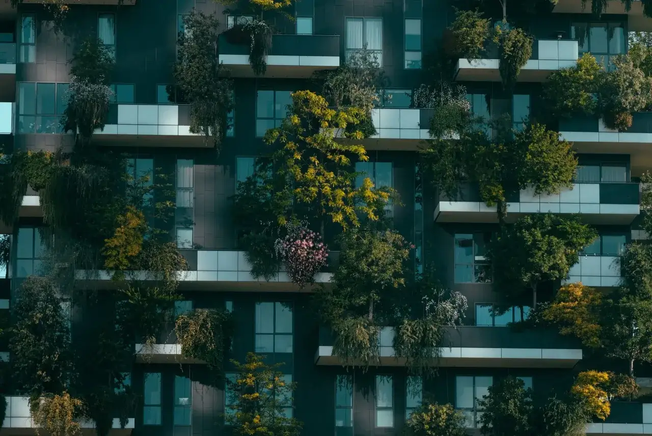 Edificio con balcones repletos de vegetación exuberante, un ejemplo de construccion 4.0 que integra naturaleza y arquitectura moderna.
