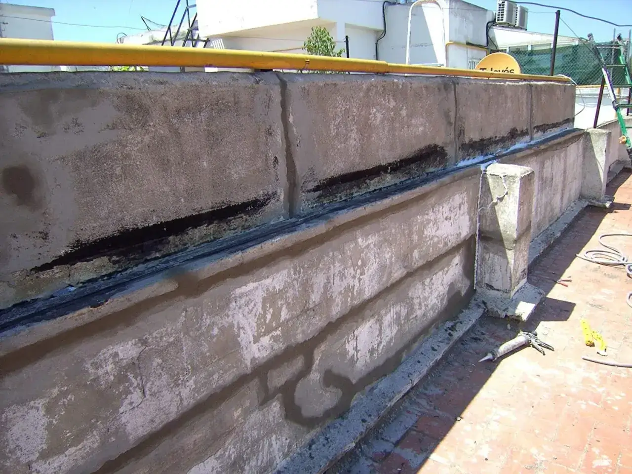 Aplicación de mortero para reparación de fachadas en una terraza. Se observa el proceso de sellado y restauración de muros de concreto.