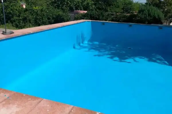 Piscina vacía con paredes pintadas de azul brillante, mostrando que se puede pintar una piscina encima del gresite.
