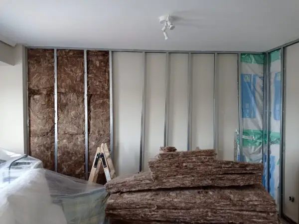 Aislamiento de pared para combatir la humedad. Se ve lana de roca y estructura metálica.